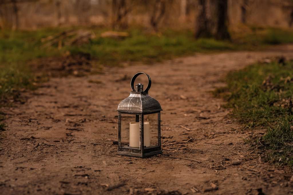 Lit lantern on a path representing hope and guidance through grief counselling