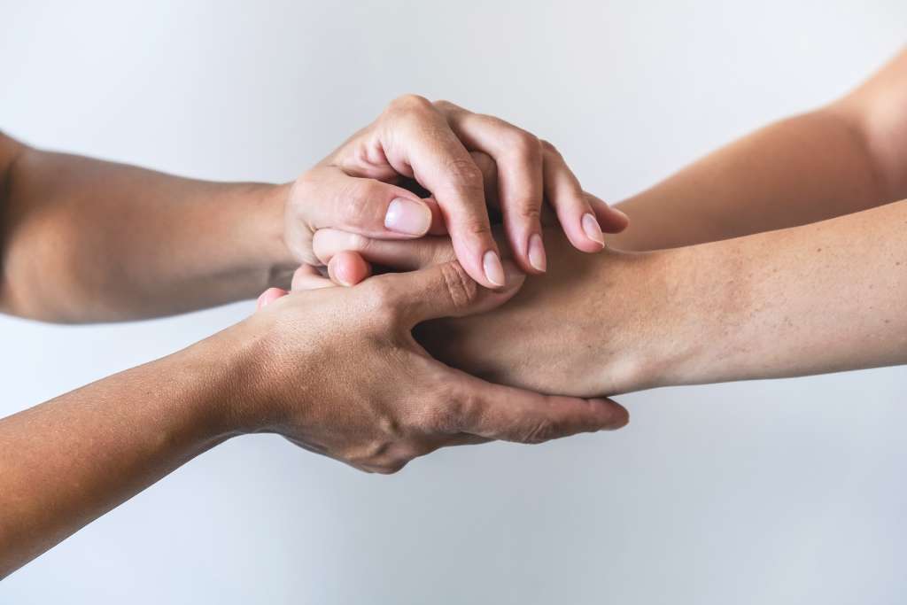 Hands joined together in support during therapy session