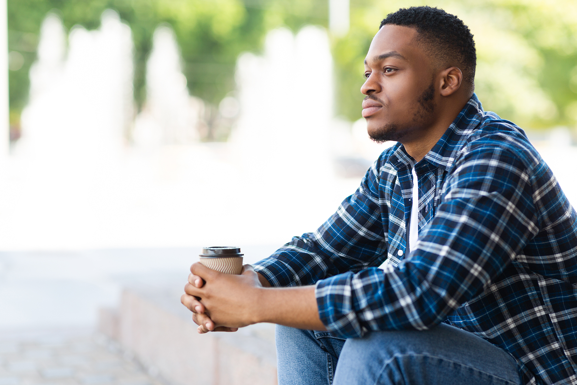 Young man sitting thoughtfully with coffee representing reflection on trauma bonding with parents