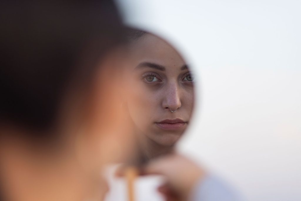 Woman with mirrored reflection representing dissociative disorders and trauma response