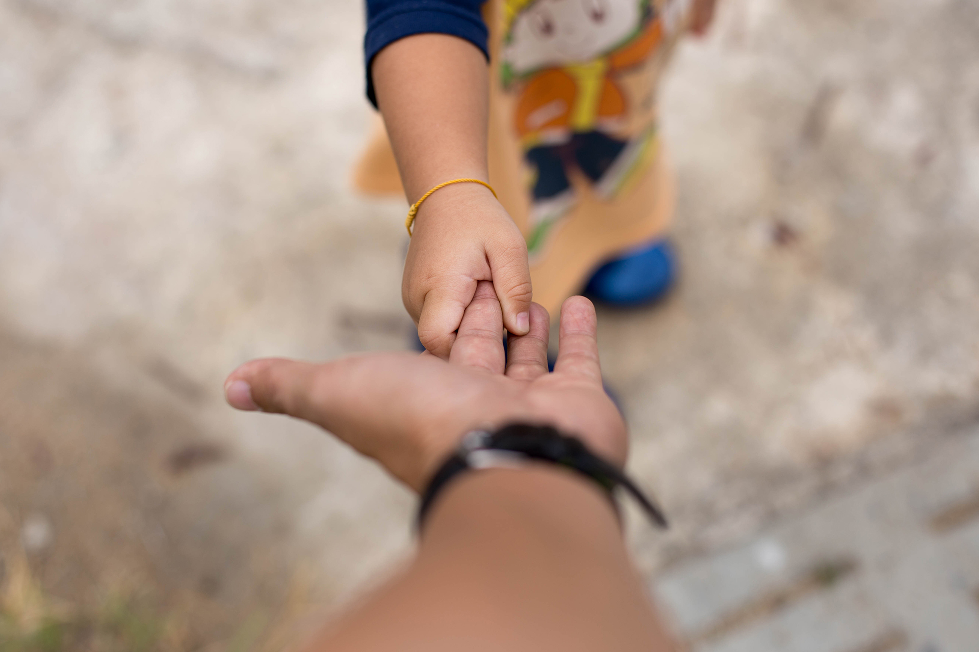 Adult reaching out to child's hand symbolizing anxious attachment and connection