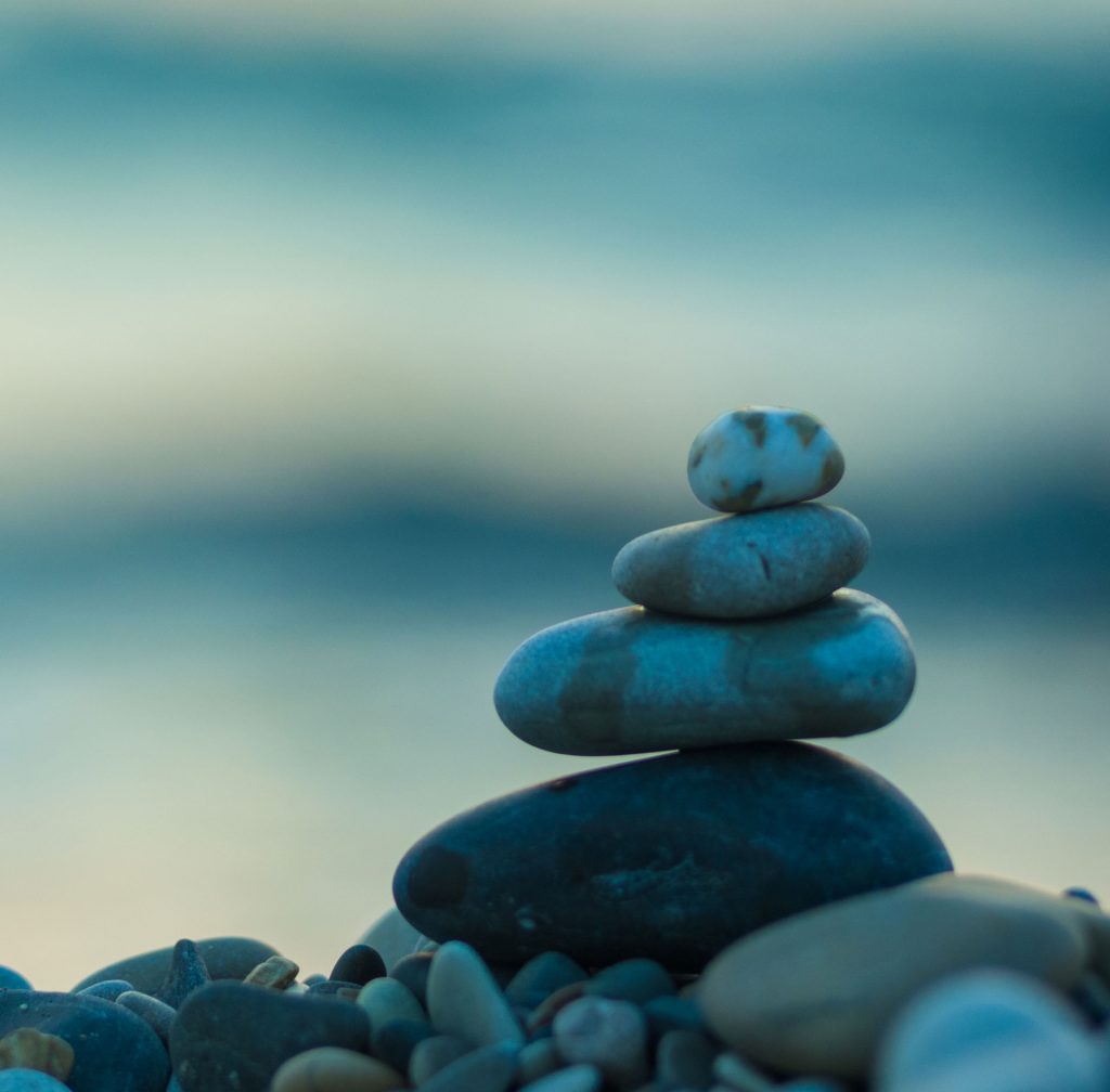 Stacked stones balanced by calm water — representing mindfulness, stability, and the process of healing through trauma therapy in Abbotsford